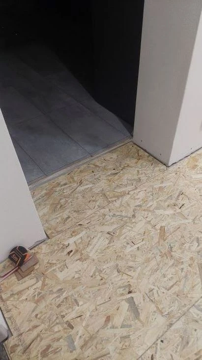 Nainstalované OSB desky na podlaze s měřicím pásmo.