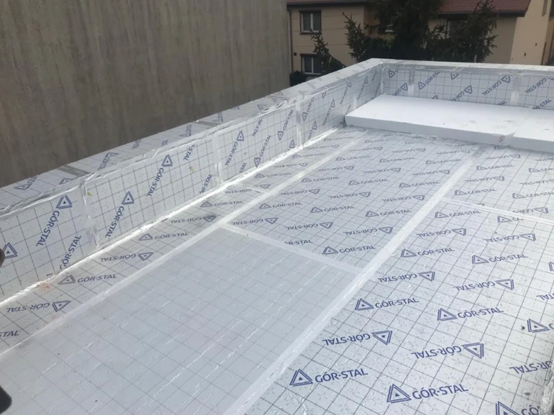 Instalace izolačních desek na střeše s ochrannou fólií.