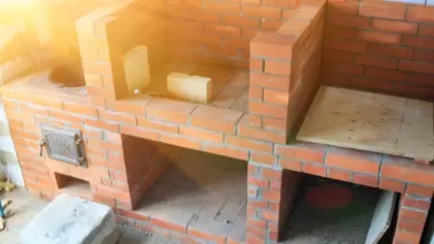 Částečně postavený zahradní gril z cihel s více komorami.