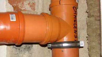 Oranžová plastová hadice pro odvod páry z digestoře.