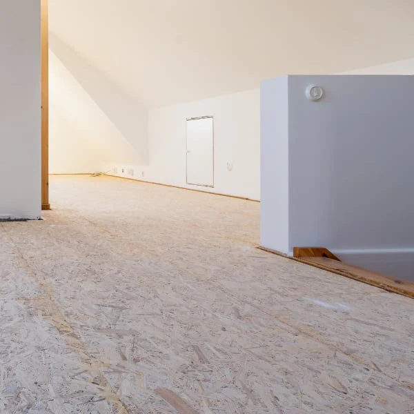 Instalace desek OSB na podlahu v interiéru.