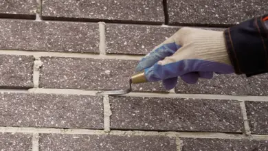 Ruční nástroj pro spárování dlažby na venkovní zdi.