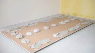 Sádrokartonová deska s vrstvami lepidla připravenou k montáži na zeď.