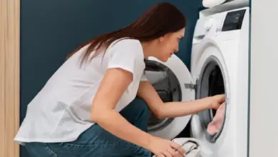 Žena nakládá prádlo do pračky, ne ukazuje napojení na sifon.
