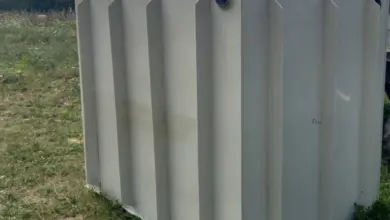 Bílá plastová septikova nádrž na trávnate ploše venku.