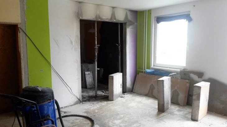 Vnitřní prostor po bourání nosné zdi s otevřeným průchodem.