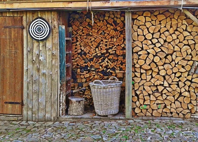 Dřevo správně uskladněné v homole s košíkem vedle.