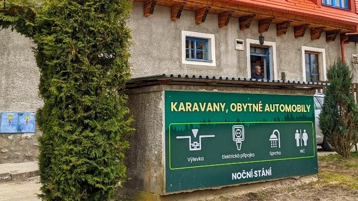 Zelená tabule s ikonami pro vyprázdnění chemického záchodu na kempu.