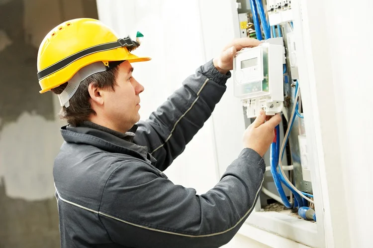 Elektrikář pracuje na podružném rozvaděči s viditelným zapojením.