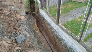 Výkop pro vodovodní přípojku s položenými potrubím.