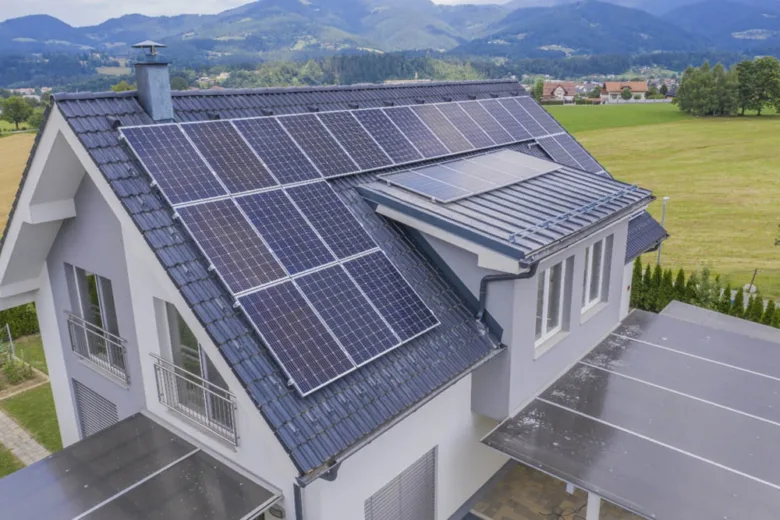 Modern dům s fotovoltaickými panely na střeše.