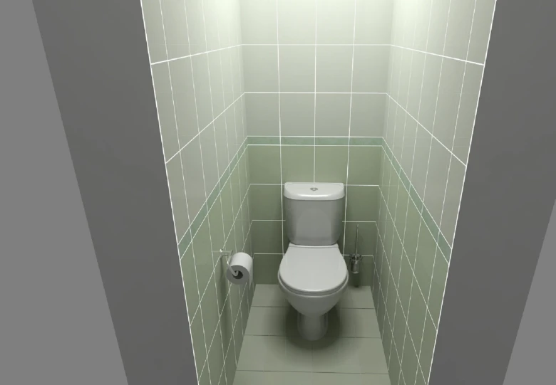 Bílá toaleta v úzké zeleně obložené koupelnové kabince.