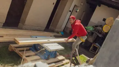 Muž pilaře řezá dřevo pro provětrávanou fasádu.