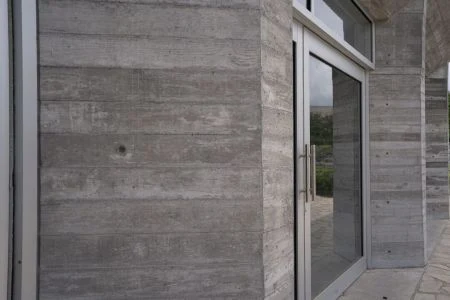 Pohledový beton na fasádě budovy s dveřmi