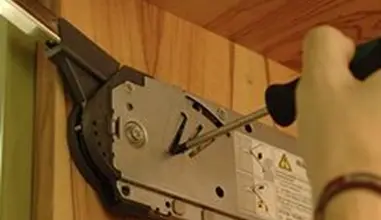 Ruční úprava montážního mechanismu kuchyňského dvířka šroubovákem.