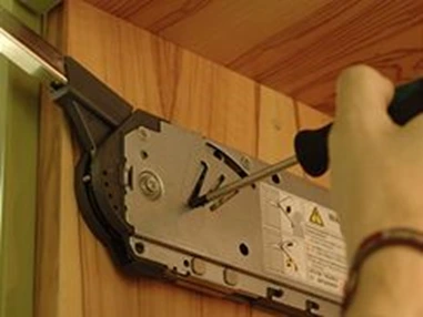 Ruční úprava montážního mechanismu kuchyňského dvířka šroubovákem.