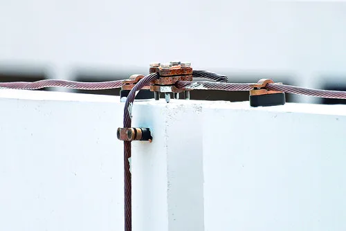 Detailní pohled na spojení hromosvodu s kovovým držákem.