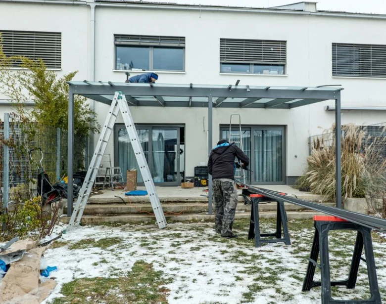 Stavba kovové pergoly na zahradě s pracovníky.