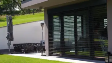 Špalety na oknech venkovní fasády domu s bílou zdí.
