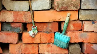 Hromada červených cihel s nástroji pro stavbu chodníku.