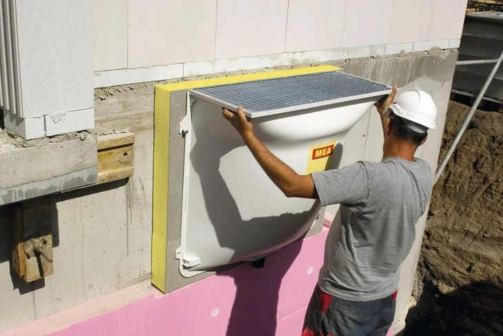 Montáž světlíku na fasádu domu během stavebních prací.
