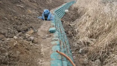 Práce na úpravě svahu s instalací drenážních trubek a terénními změnami.