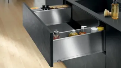 Otevřený kuchyňský zásuvkový organizér plný čistících prostředků.
