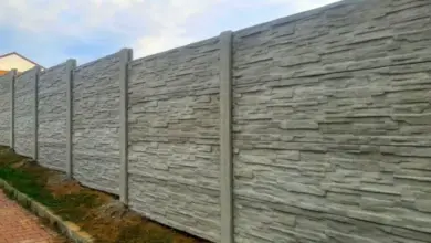 Hotový betonový plot s kamennou úpravou na svahu vedle cesty.