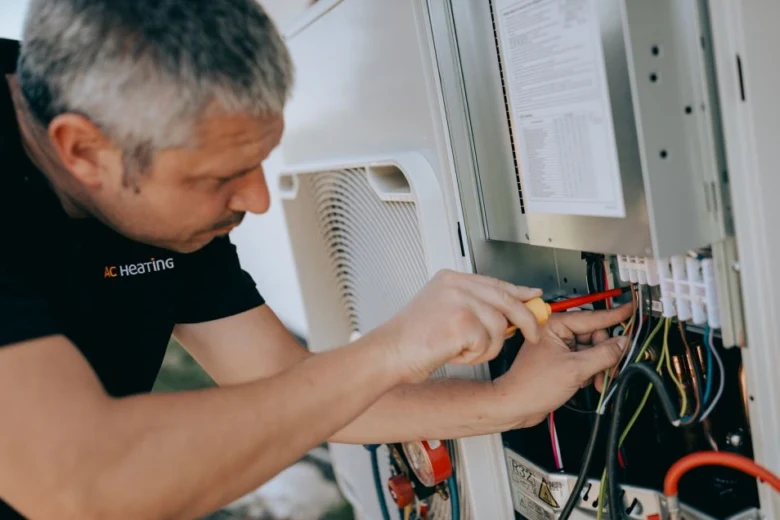 Technik montuje tepelné čerpadlo pro starší domy.