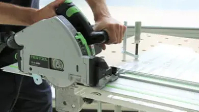 Muž řezá plexisklo pilou na kolejnici značky Festool.
