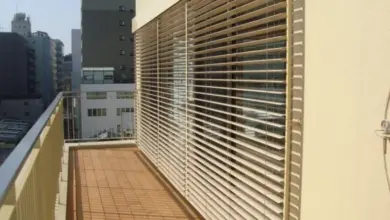 Venkovní žaluzie na balkóně s výhledem do města.