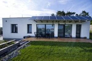 Moderní novostavba s fotovoltaickými panely na střeše.
