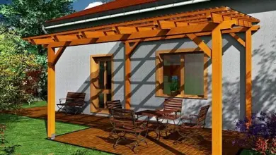 Dřevěný altán s podlahou z prkenného povrchu připojený k domu.