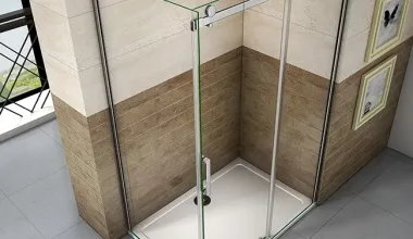 Moderní sprchový kout s dlažbou a skleněnou přepážkou.