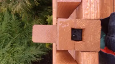 Detail spoje dřevěného balkonu s přírodním okolím.