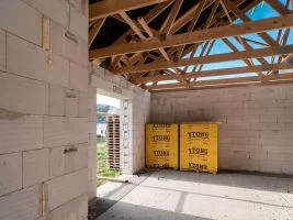 Nezhotovený interiér s plynosilikátovými tvárnice a izolačními materiály.