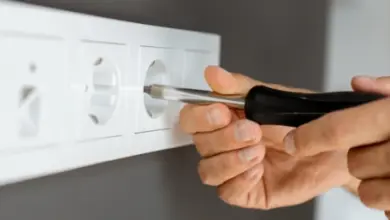 Ruční montáž elektrické zásuvky do zdi šroubovákem.