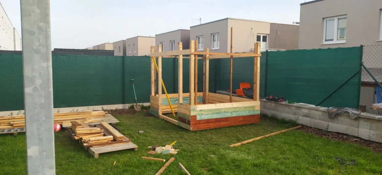 Stavba dřevěného zahradního domku v průběhu stavby na trávníku.