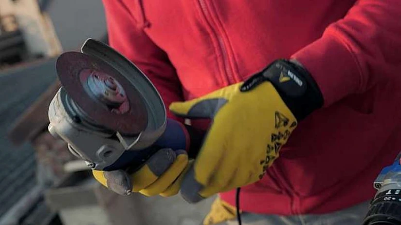 Osoba drží brusku s kotoučem pro údržbu vrtáků do betonu