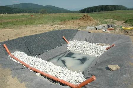 Výkop pro kořenovou čističku s kamenivem a hadicemi.