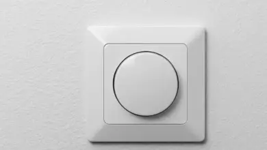 Moderní bílý elektrický vypínač na zdi v interiéru.