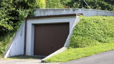 Garáž zapuštěná do svahu s bránou a zeleň