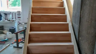 Dřevěné schodiště v stavbě bez zábradlí na staveništi.