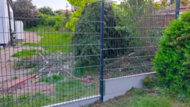 Plot s drátěným plotem na svahu v zahradním terénu.
