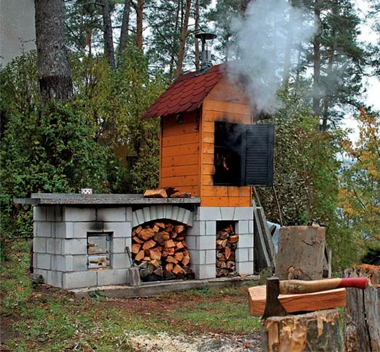 Samostatně postavená udírna z bloků a dřeva s komínem.