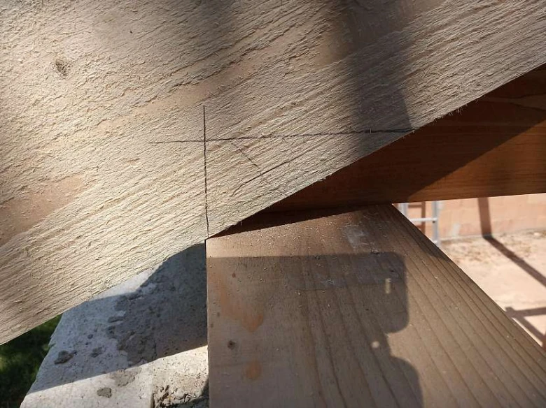 Detail dřevěného krovu s označením pro řezání trámů.