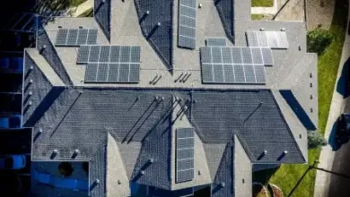 Vzdušný pohled na střechy domů s fotovoltaickými panely.