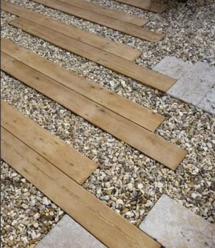 Dřevěné prkna na štěrku pro moderní terasu.