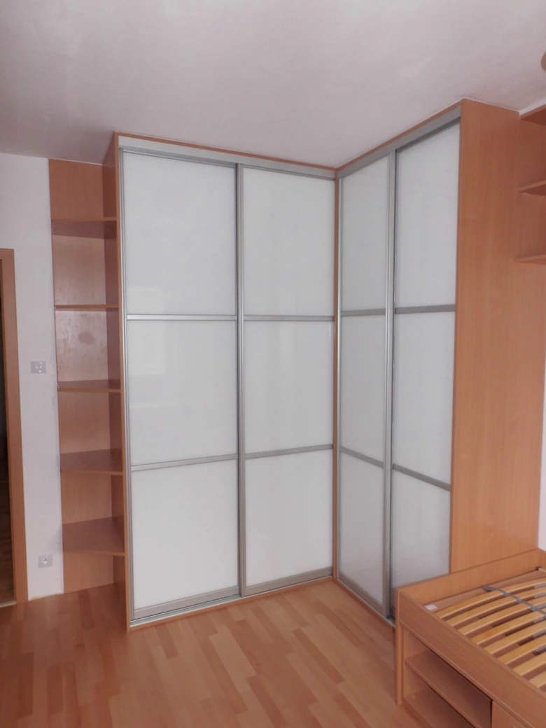 Vestavěná skříň v rohu s posuvnými dveřmi ukazuje hloubku.