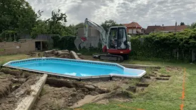 Bazén v zahradě během úpravy terénu s výkopovou technikou.